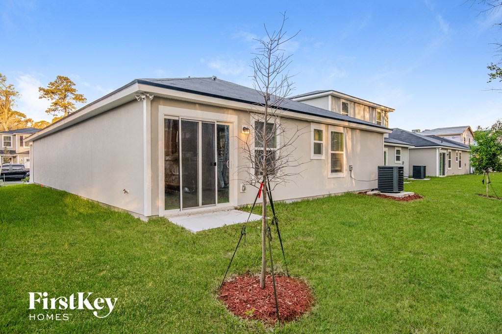a white house with a tree in the yard
