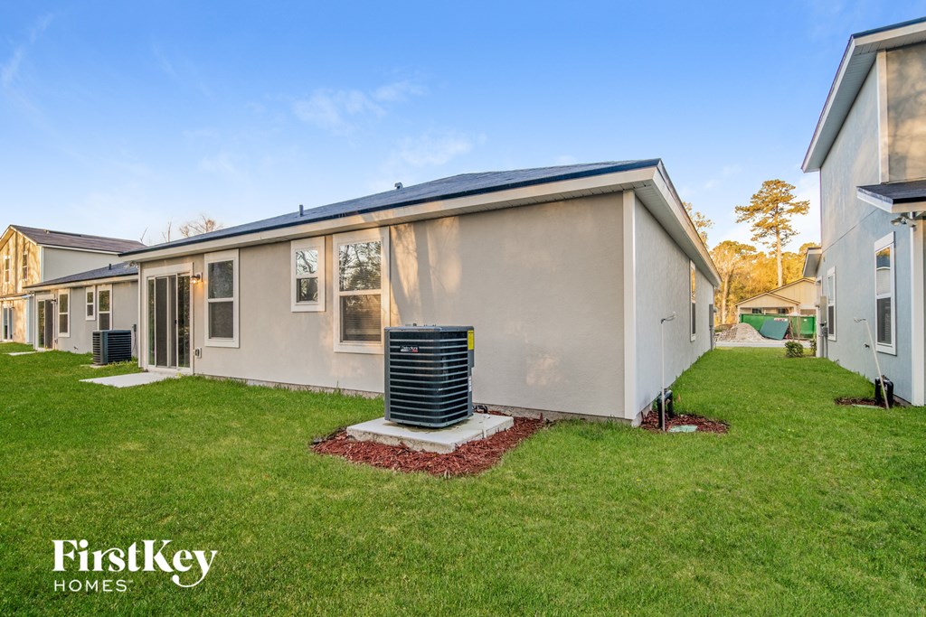 a beige house with a heater in the grass