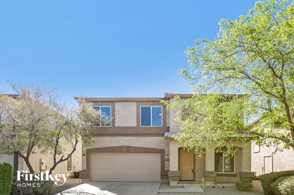 a house with a garage and trees in front of it