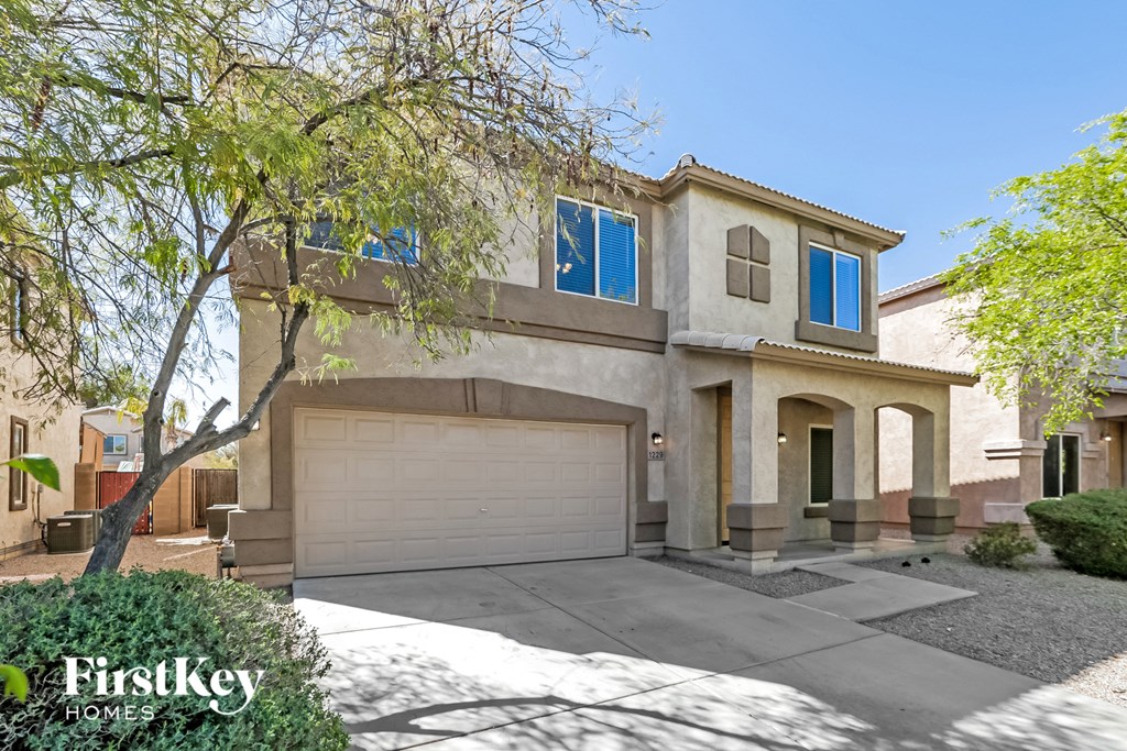 a house with a garage door and a tree