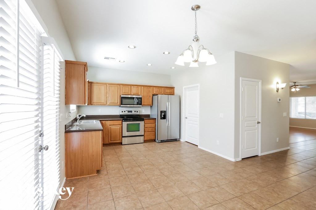 an empty kitchen with wooden cabinets and stainless steel appliances