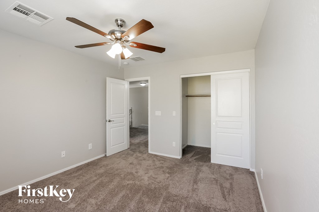 a living room with carpet and a ceiling fan