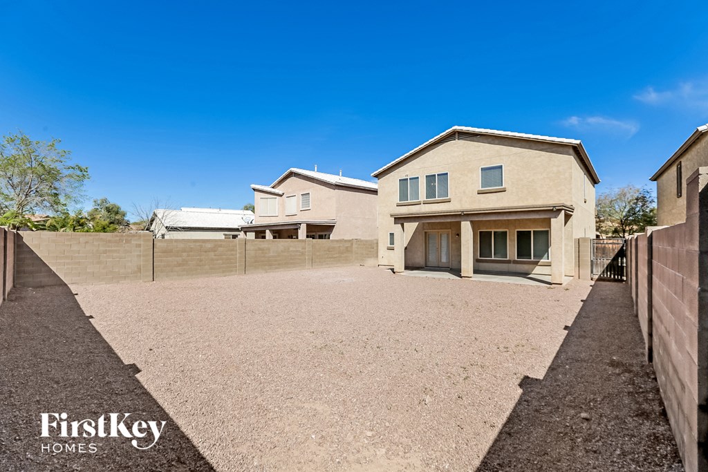 a house with a gravel driveway and a fence