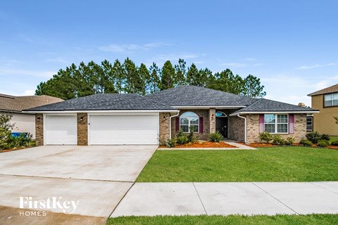 a brick house with a gray roof and a driveway