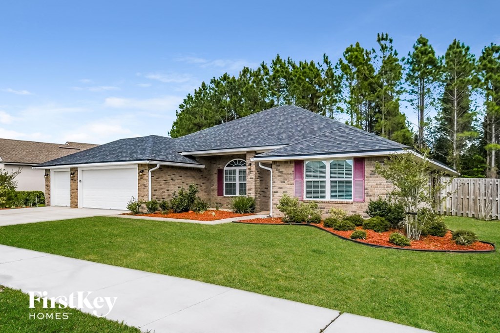 a home with a lawn and a sidewalk in front of it