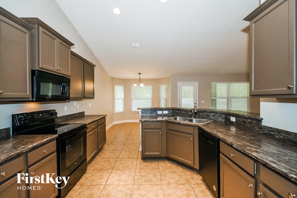 a large kitchen with granite counter tops and stainless steel appliances
