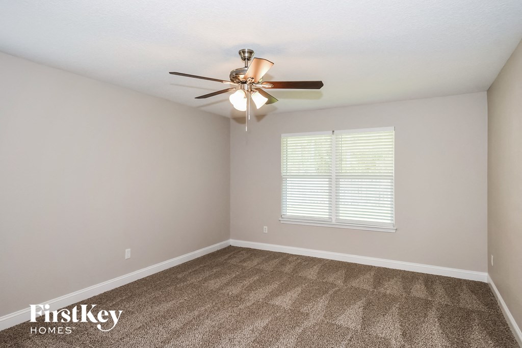 a bedroom with carpet and a ceiling fan