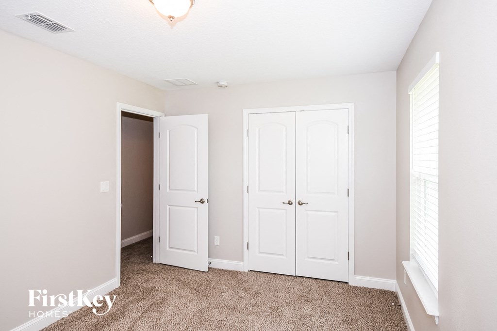 a bedroom with two closets and a carpeted floor