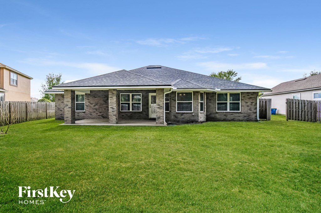 a small brick house in a grassy backyard