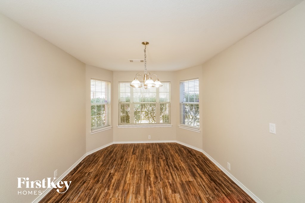 A room with wooden floors and a chandelier.