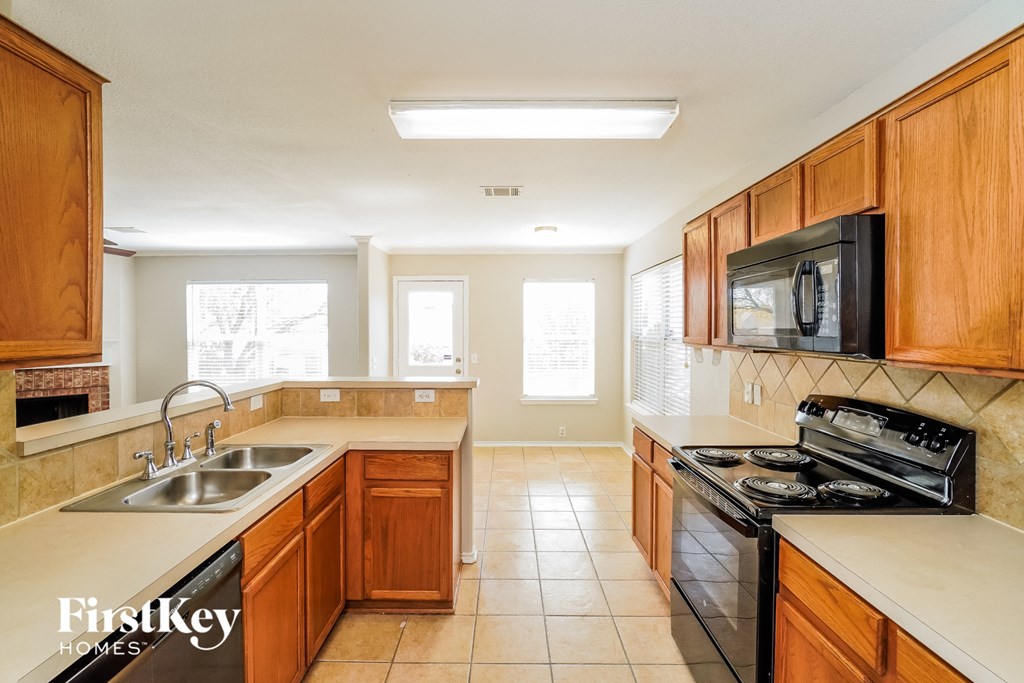 A kitchen with wooden cabinets and a black stove top oven.