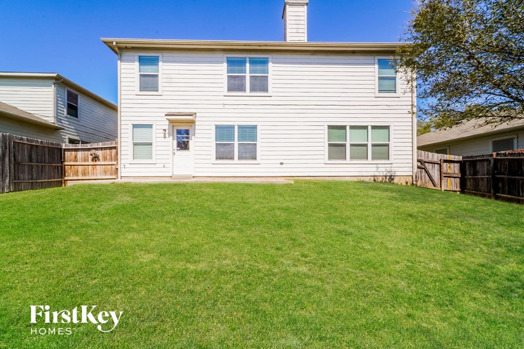A white house with a green lawn in front of it.