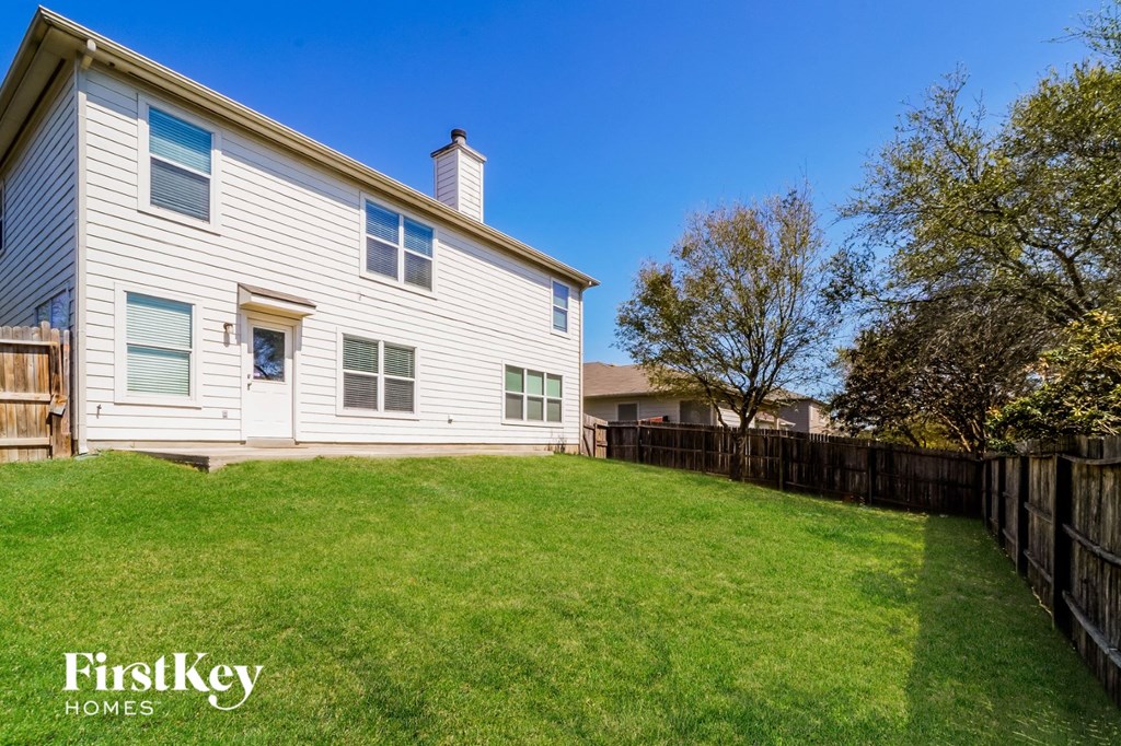 A house with a fence and a grassy yard.
