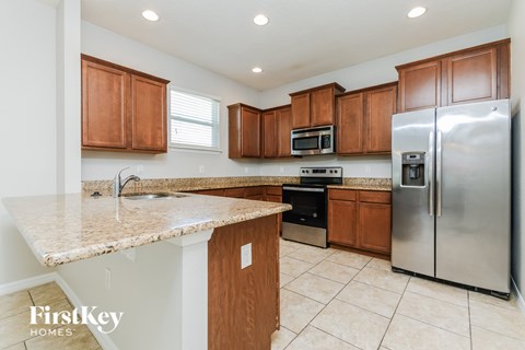 A kitchen with wooden cabinets and a granite countertop.
