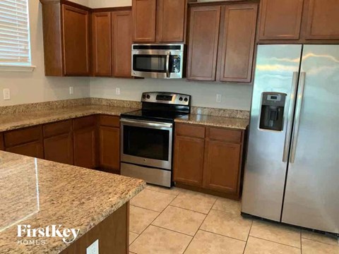 an updated kitchen with stainless steel appliances and granite counter tops