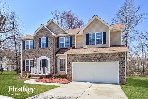 a home with a white garage door and a brick house