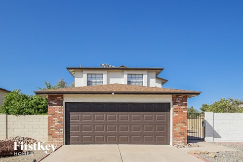 a brown garage door in front of a brick house