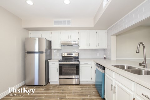 a kitchen with white cabinets and stainless steel appliances