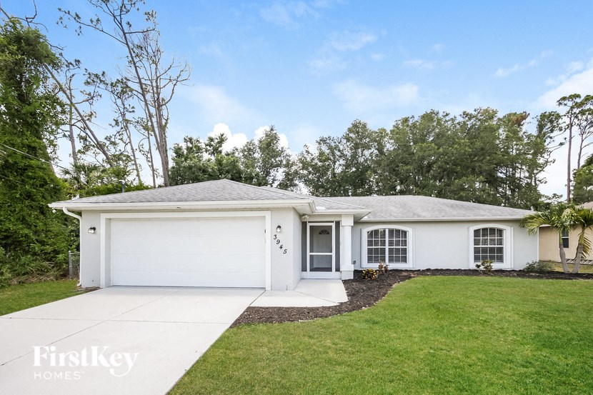 a white house with a lawn and a driveway