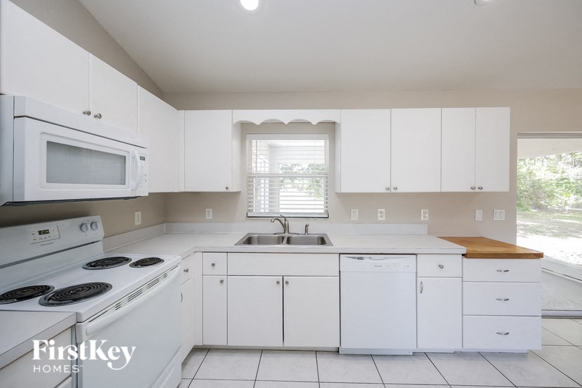 a white kitchen with white appliances and white cabinets
