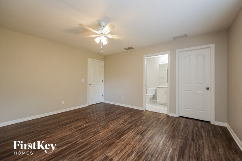 an empty living room with wood flooring and a ceiling fan