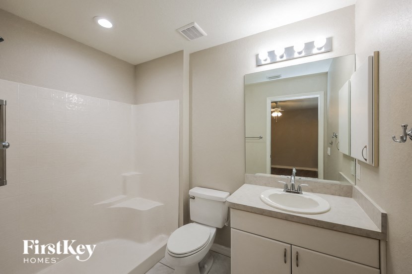 a bathroom with a sink toilet and a mirror