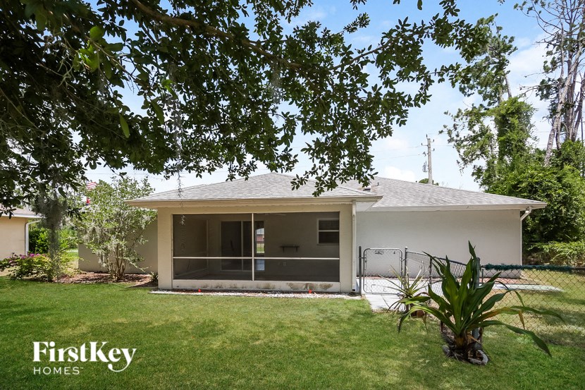 a small white house with a yard and a tree