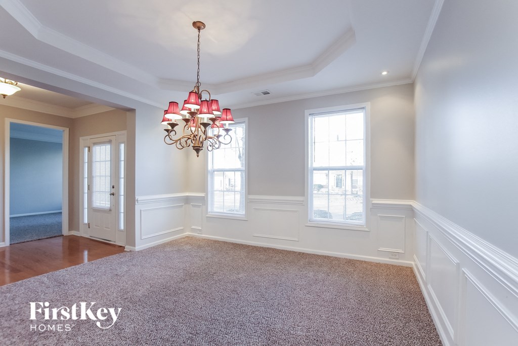 A large, empty room with a chandelier hanging from the ceiling.
