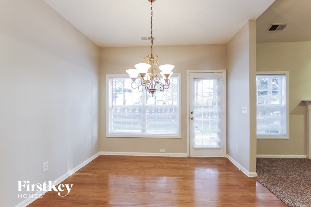 A room with a chandelier and a rug on the floor.