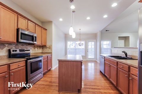 A kitchen with wooden cabinets and a FirstKey Homes logo.