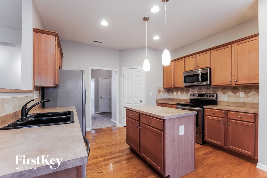 A kitchen with wooden cabinets and a granite countertop.