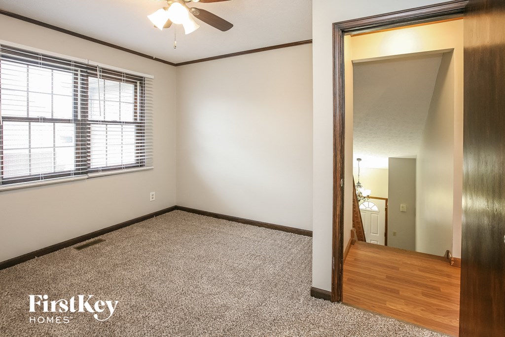 a bedroom with a large window and a door to the bathroom