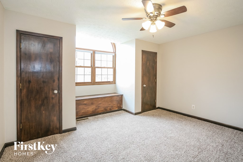 an empty room with a ceiling fan and a window