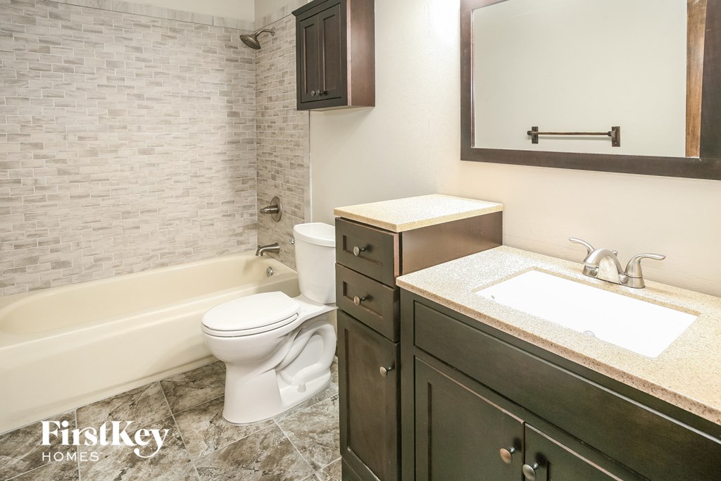 a bathroom with a toilet and a sink and a bath tub