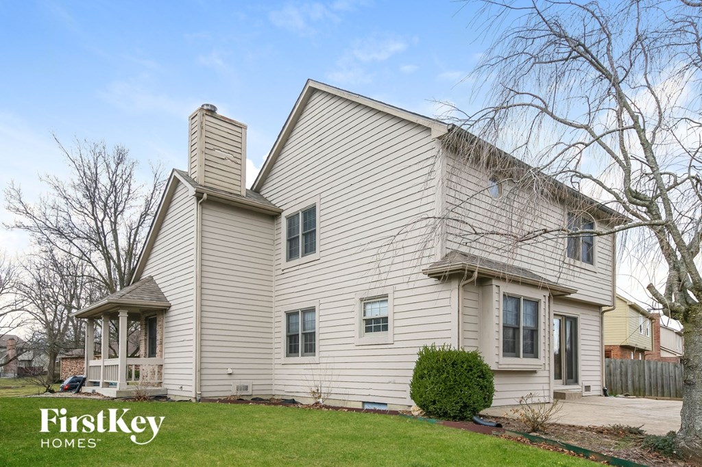 a white house with white siding and a green lawn