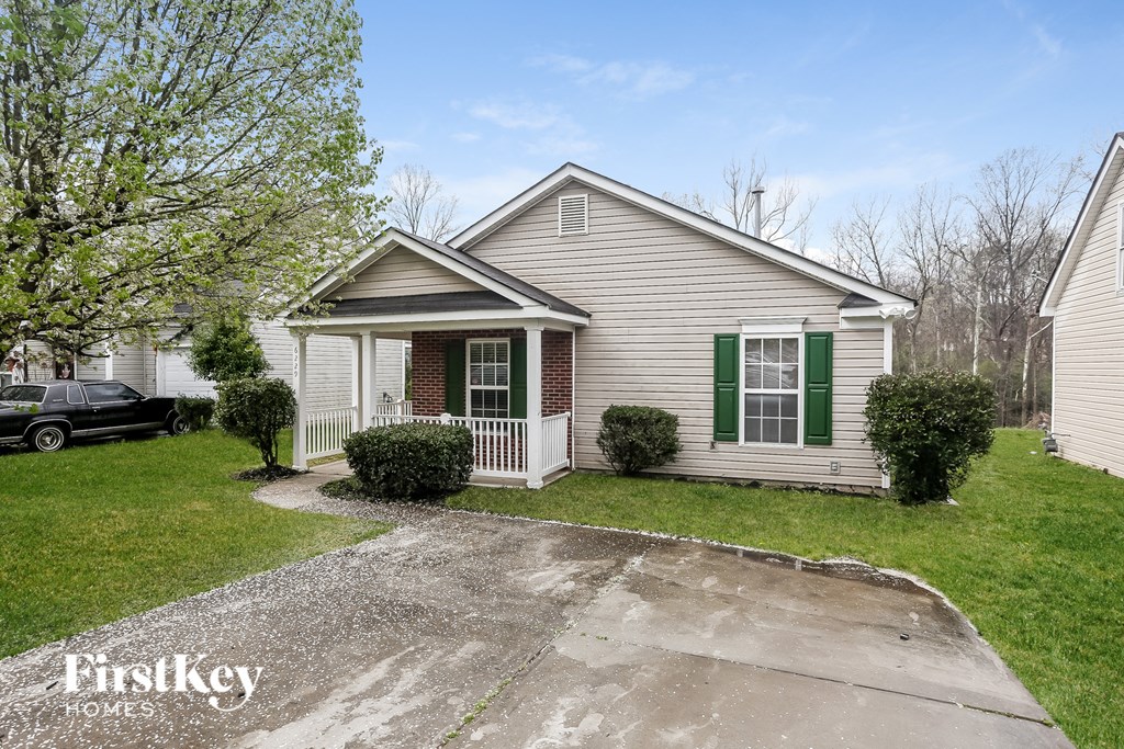 the front of a white house with green shutters and a driveway