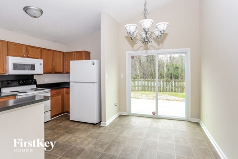 a kitchen with white appliances and a door to the yard