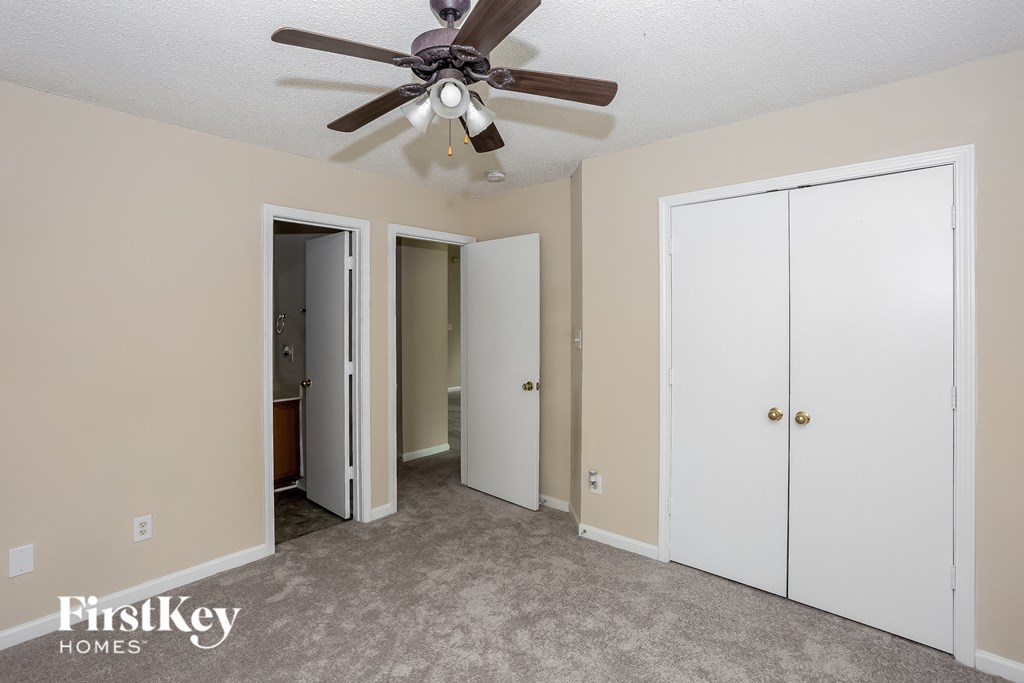 a bedroom with two closets and a ceiling fan