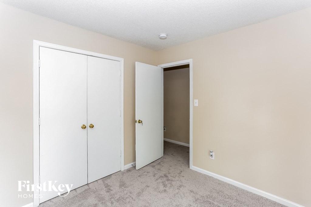 a bedroom with two closets and a door to a hallway
