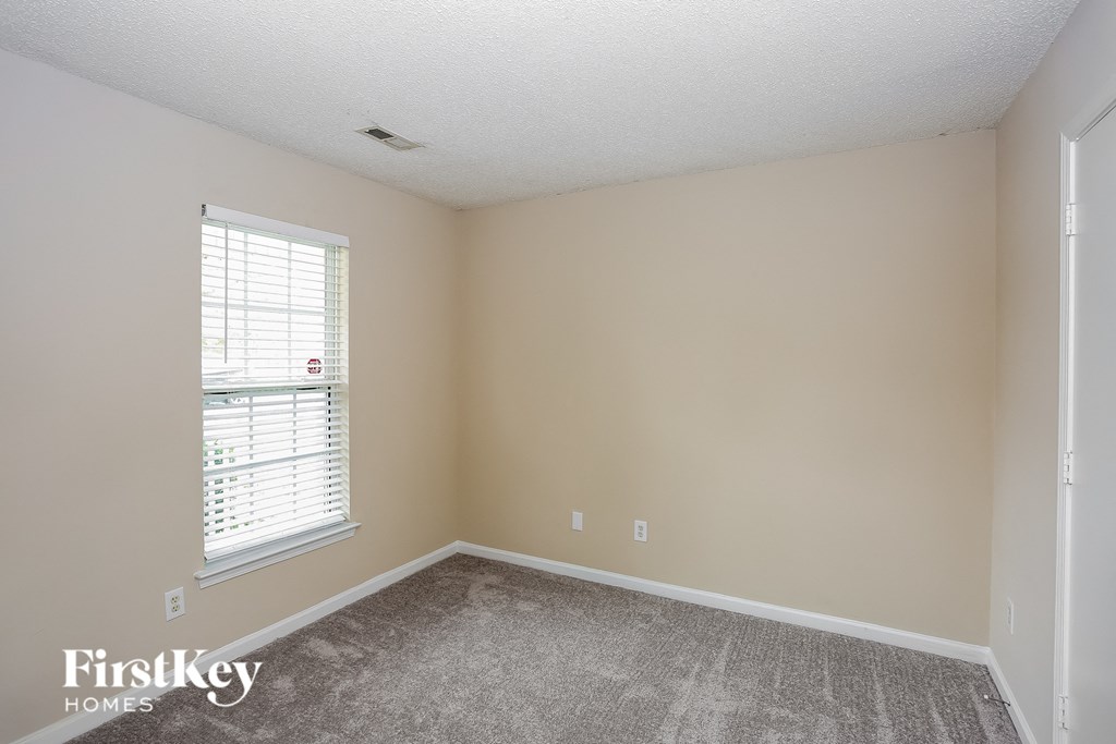 a bedroom with a carpeted floor and a window