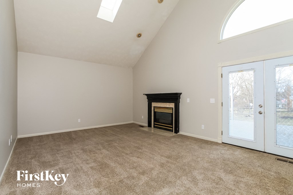 A spacious room with a fireplace and a skylight.