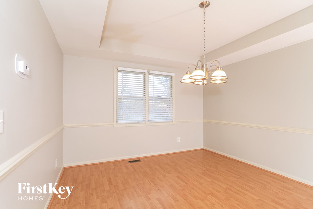 A room with wooden floors and a window with blinds.