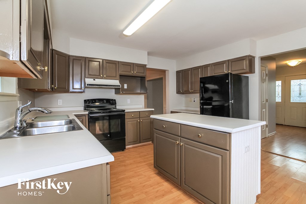 A kitchen with a white counter top and brown cabinets.