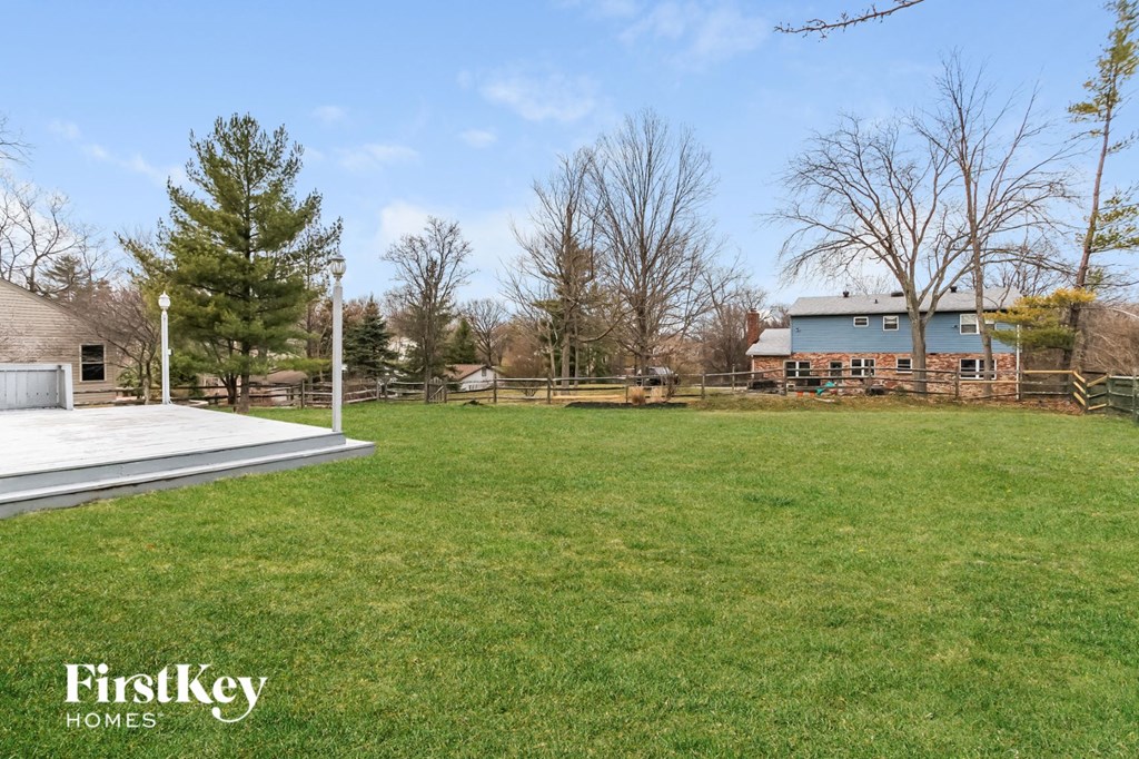 A grassy field with a building in the background and a FirstKey Homes logo.