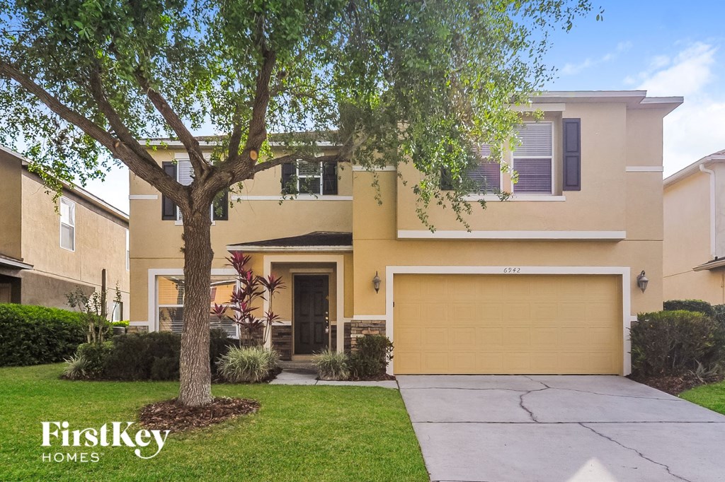 a large yellow house with a tree in front of it