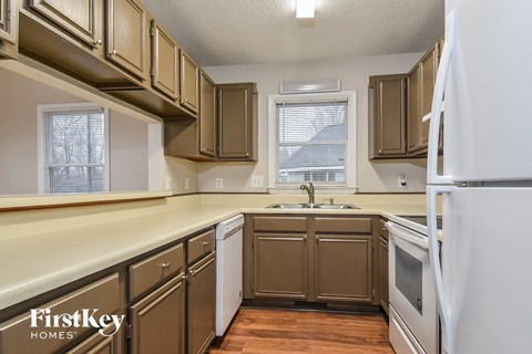 A kitchen with brown cabinets and a white refrigerator.