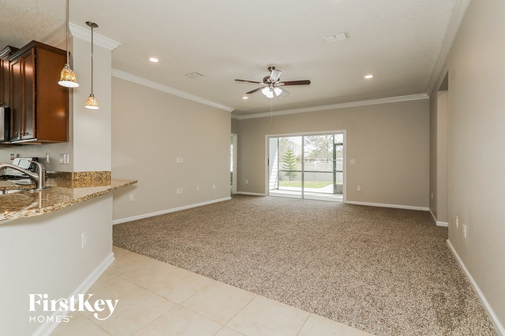 an empty kitchen and living room with a ceiling fan