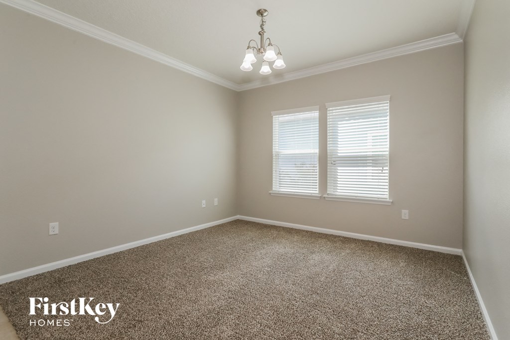 a empty room with carpet and two windows