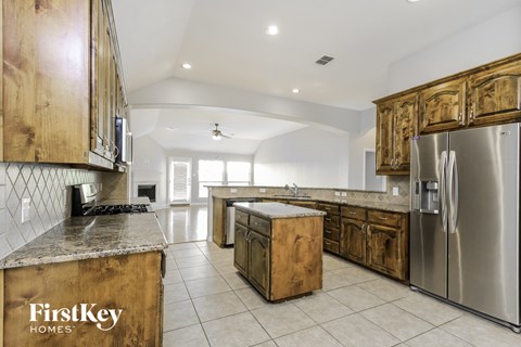 a large kitchen with stainless steel appliances and wooden cabinets