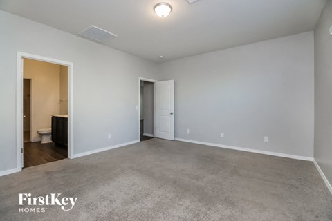 a living room with carpet and a door to a bathroom